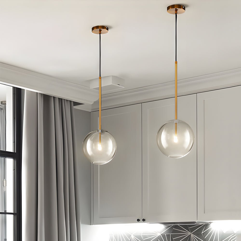 Contemporary clear glass globe pendant light with a golden finish, ideal for kitchens and living rooms with a sophisticated vibe.