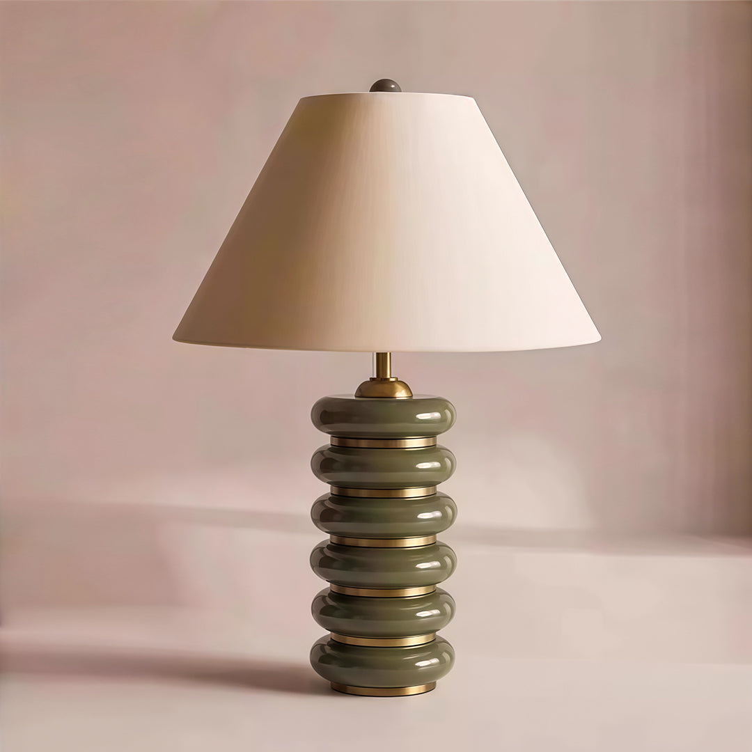 Contemporary cloth table lamp featuring glass shade chandelier aesthetic in olive green tones with organic stacked base design.