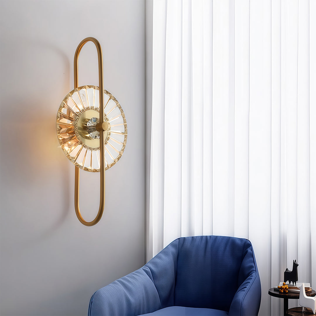 Contemporary crystal wall sconces lighting with glass shade chandelier aesthetic beside navy blue chair in modern interior.