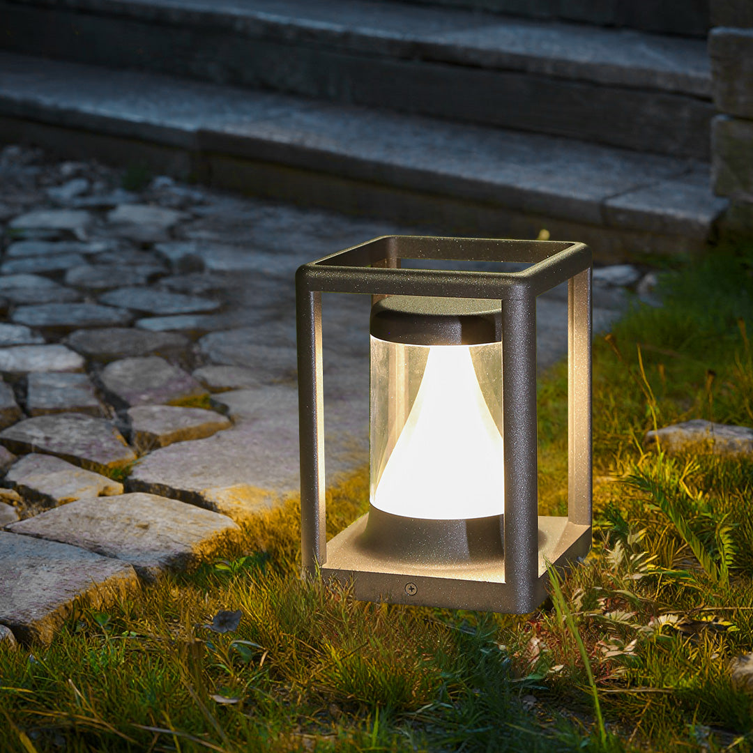 Tall cylindrical post light creating dramatic downward illumination on textured ground surface