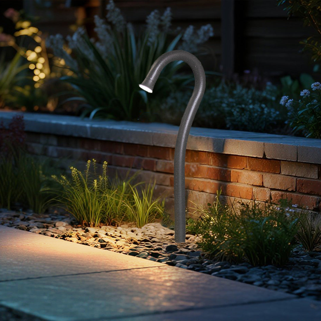 Contemporary landscape design with curved bollard lights integrated into poolside environment