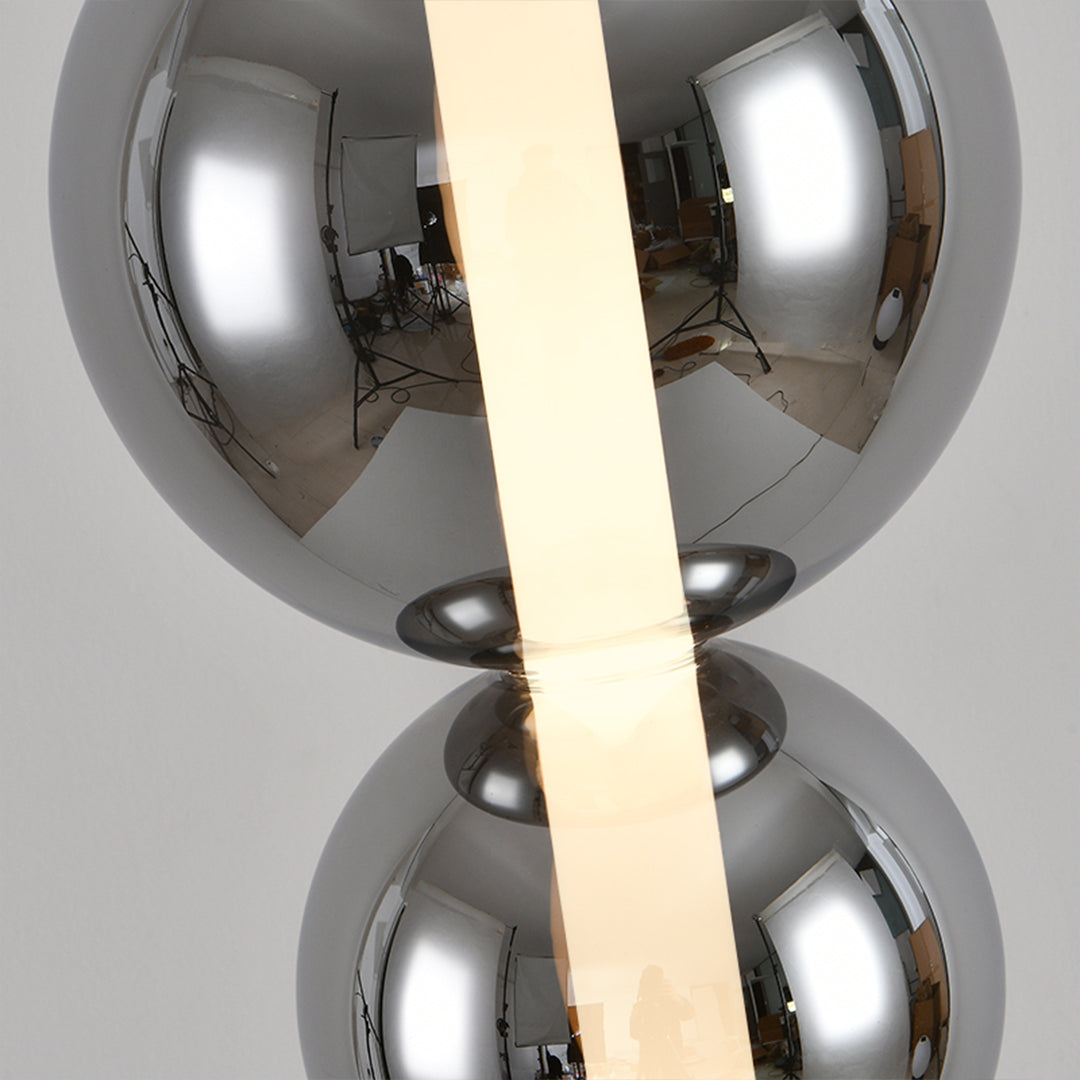 Contemporary art table lamp featuring dual chrome orbs with vertical LED strip illumination
