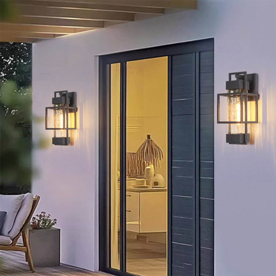 Contemporary outdoor lighting installation with black lanterns flanking modern glass entrance
