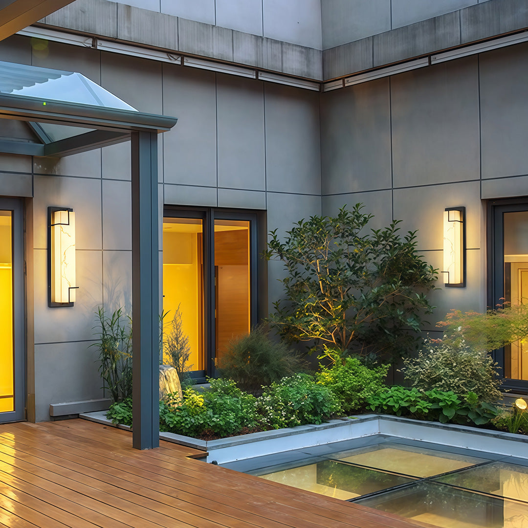 Contemporary exterior wall lights black with glass shade chandelier aesthetic illuminating modern courtyard with glass walls and greenery.