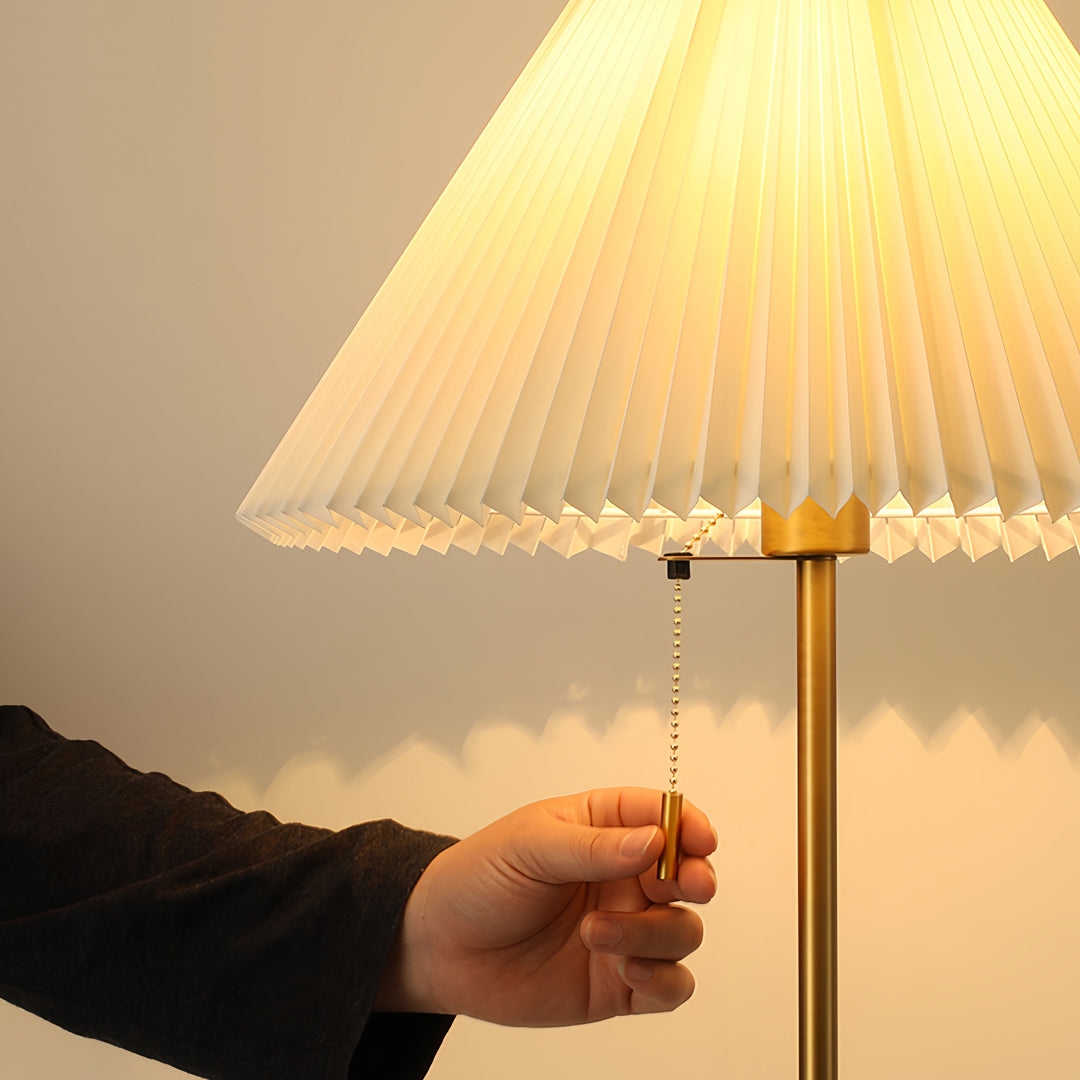 Contemporary floor wood lamp with pleated shade creating warm illumination in modern interior setting