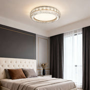 Contemporary flush mount light installed in a modern bedroom with a neutral color palette, providing warm illumination.