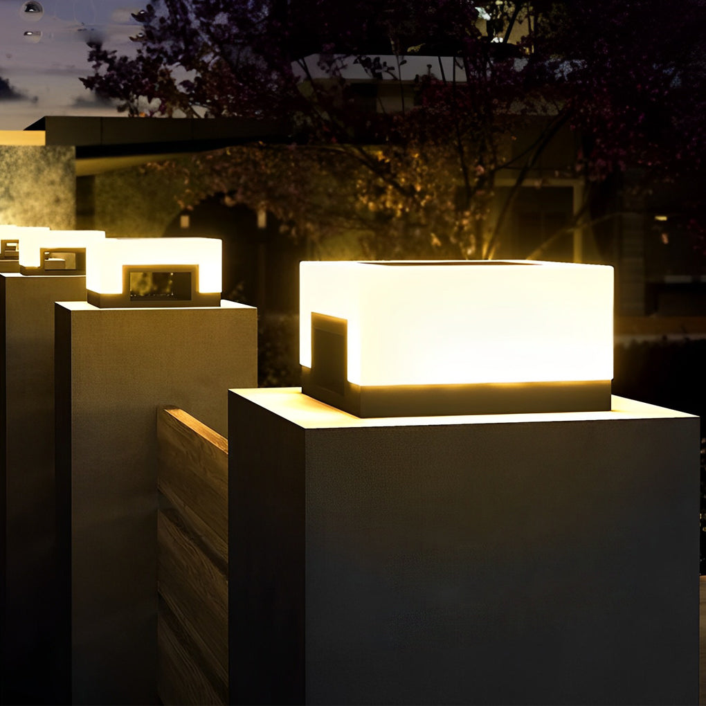 Contemporary front lawn solar lights mounted on square posts at night.