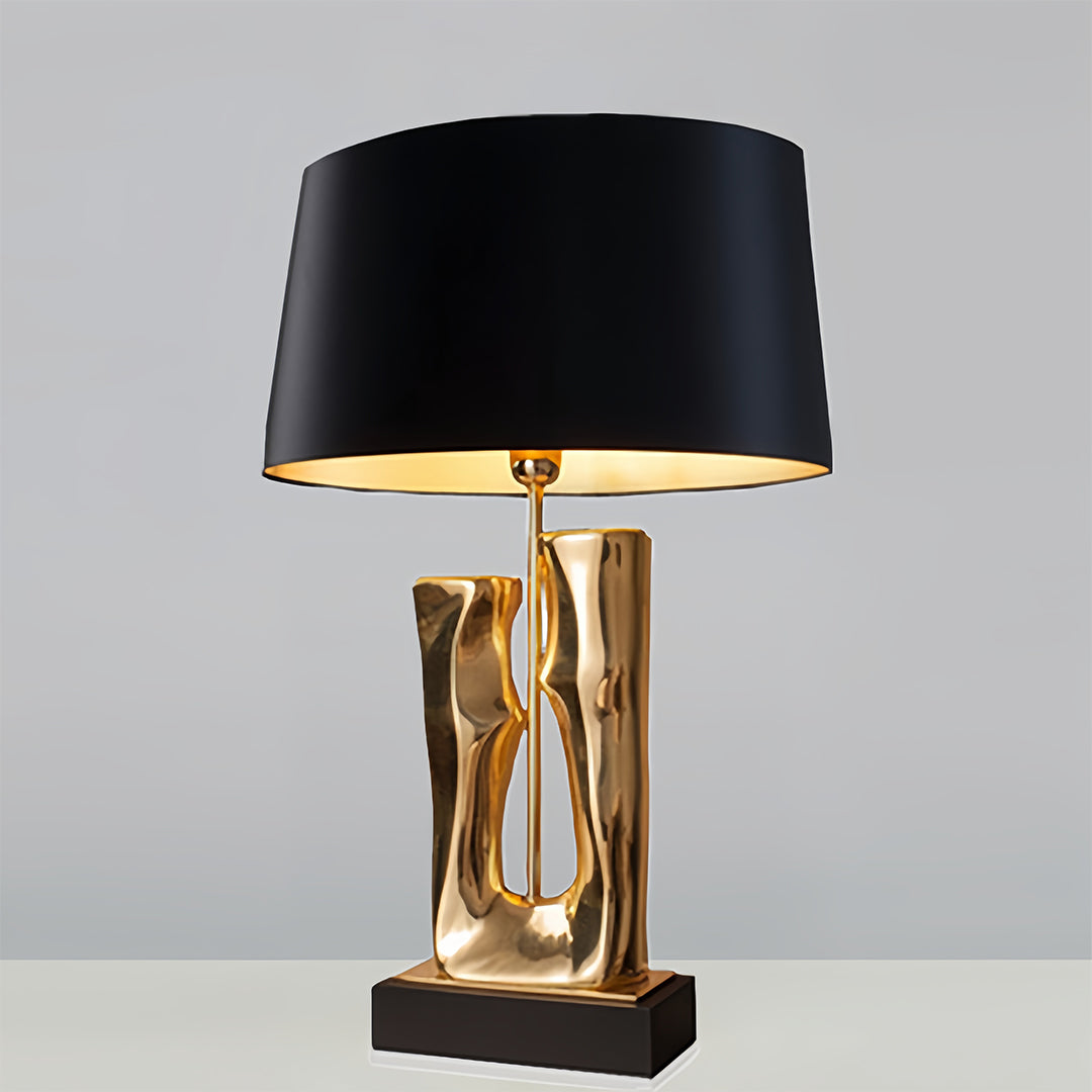 Contemporary gold and black table lamp displayed against neutral background for product showcase