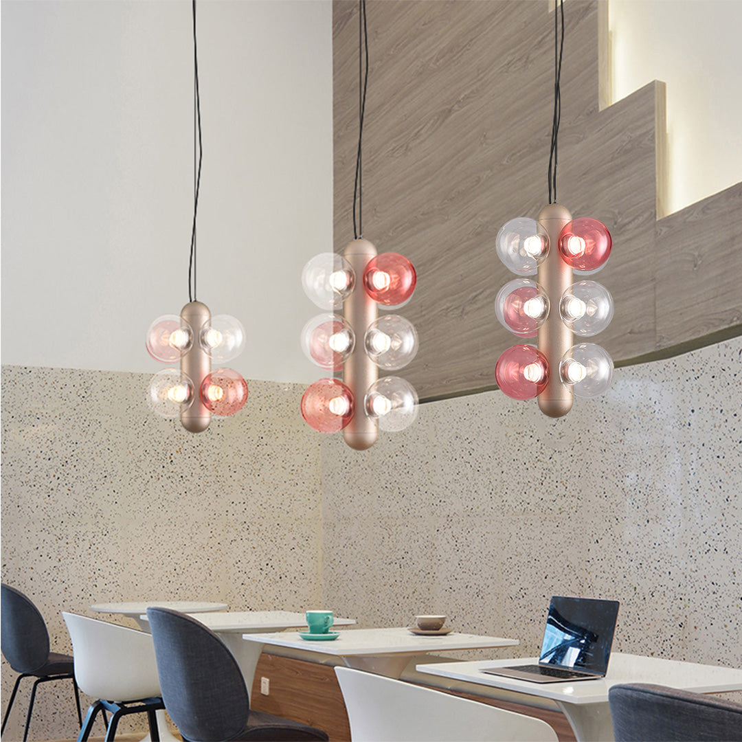 Contemporary hanging light fixture featuring cascading spherical glass shades in rose and clear tones