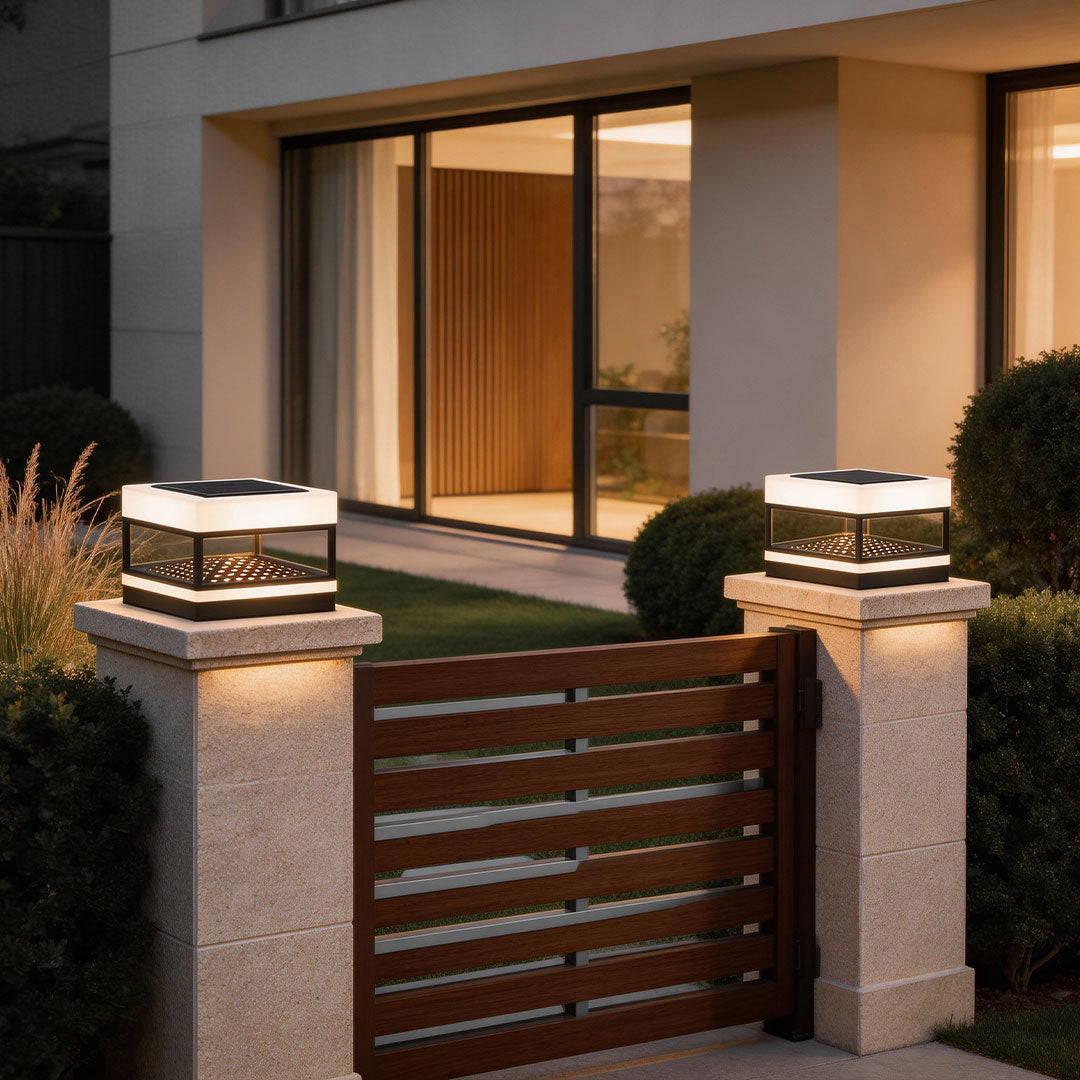 Modern white pillar top lights installed at the entrance of a contemporary house with warm lighting.