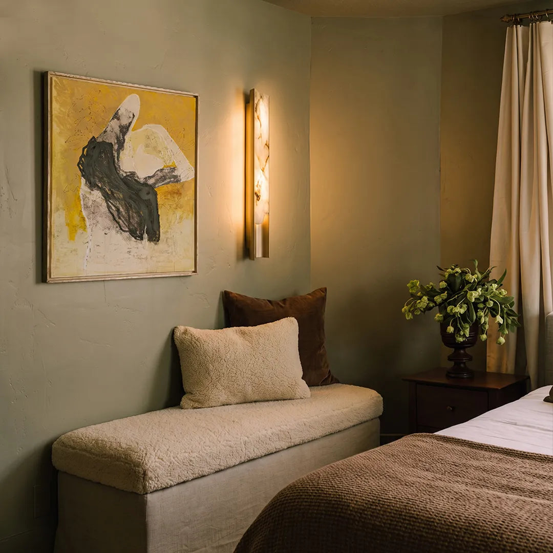 Contemporary indoor wall lights brightening a bench seating area with modern wall art.