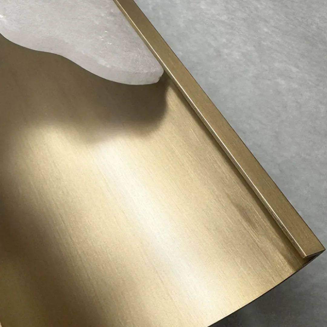 Contemporary indoor wall lights detail showing a brushed brass metal accent and curved form.