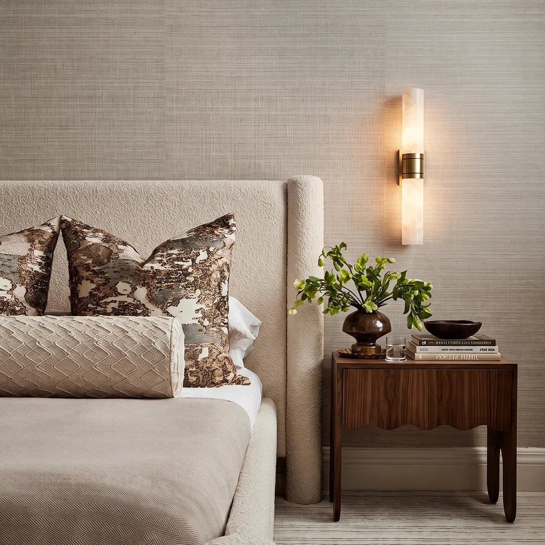 Contemporary indoor wall sconces installed above a bedside table with a sleek vertical profile and warm illumination.
