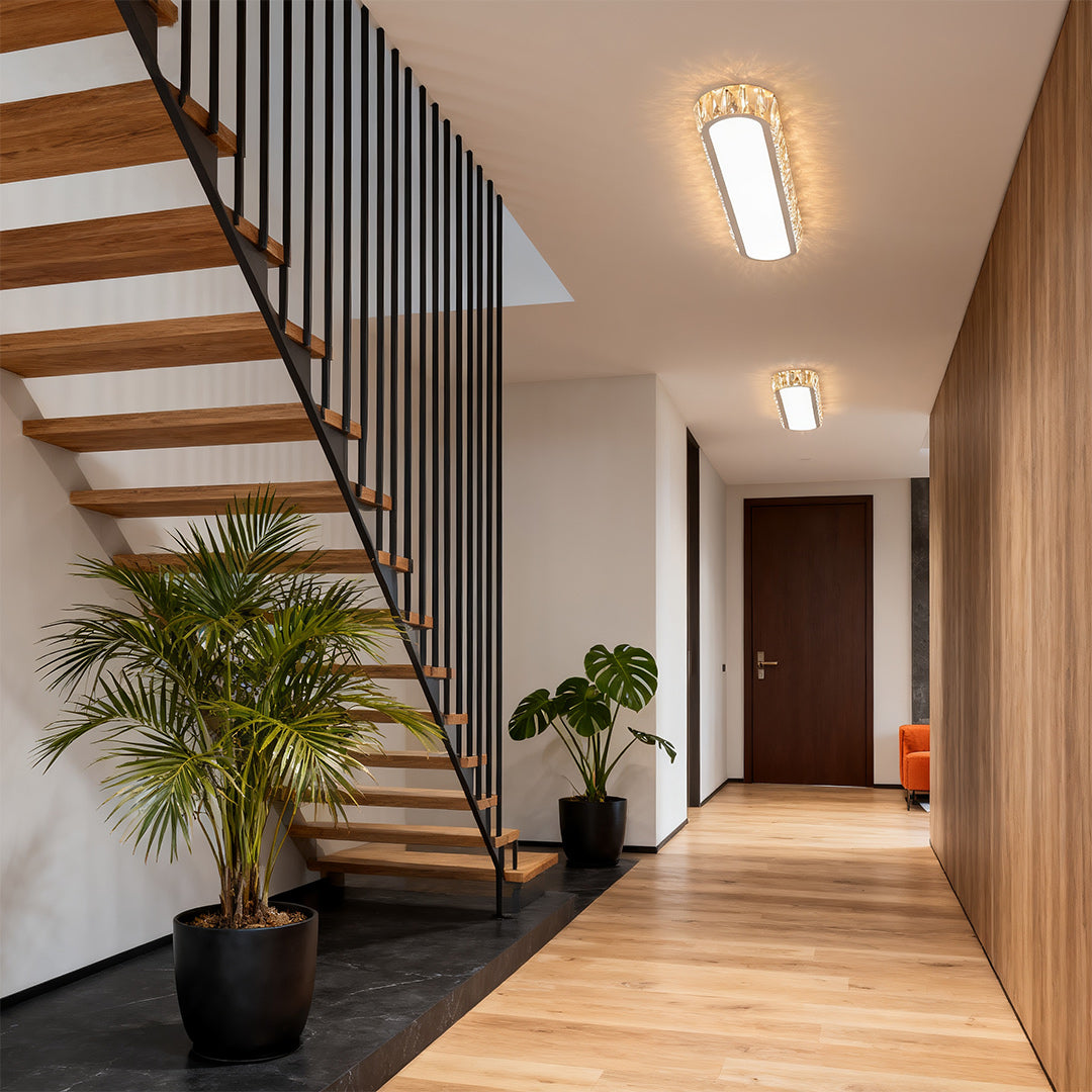 Contemporary LED flush mount light fixture with glass shade chandelier aesthetic illuminating modern hallway with wooden stairs.