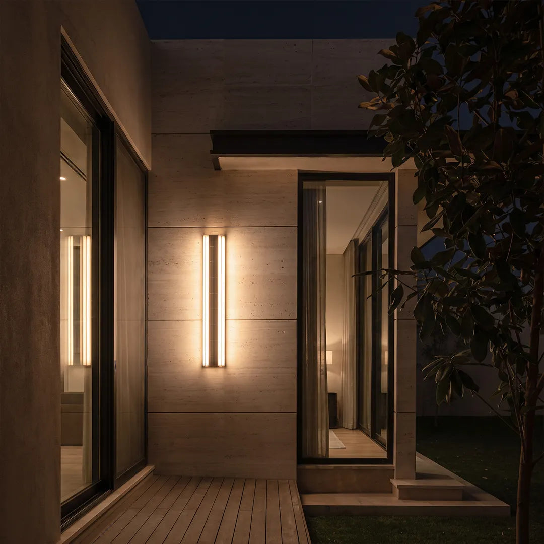 Contemporary LED wall lights installed along a modern exterior entry corridor with warm vertical illumination.