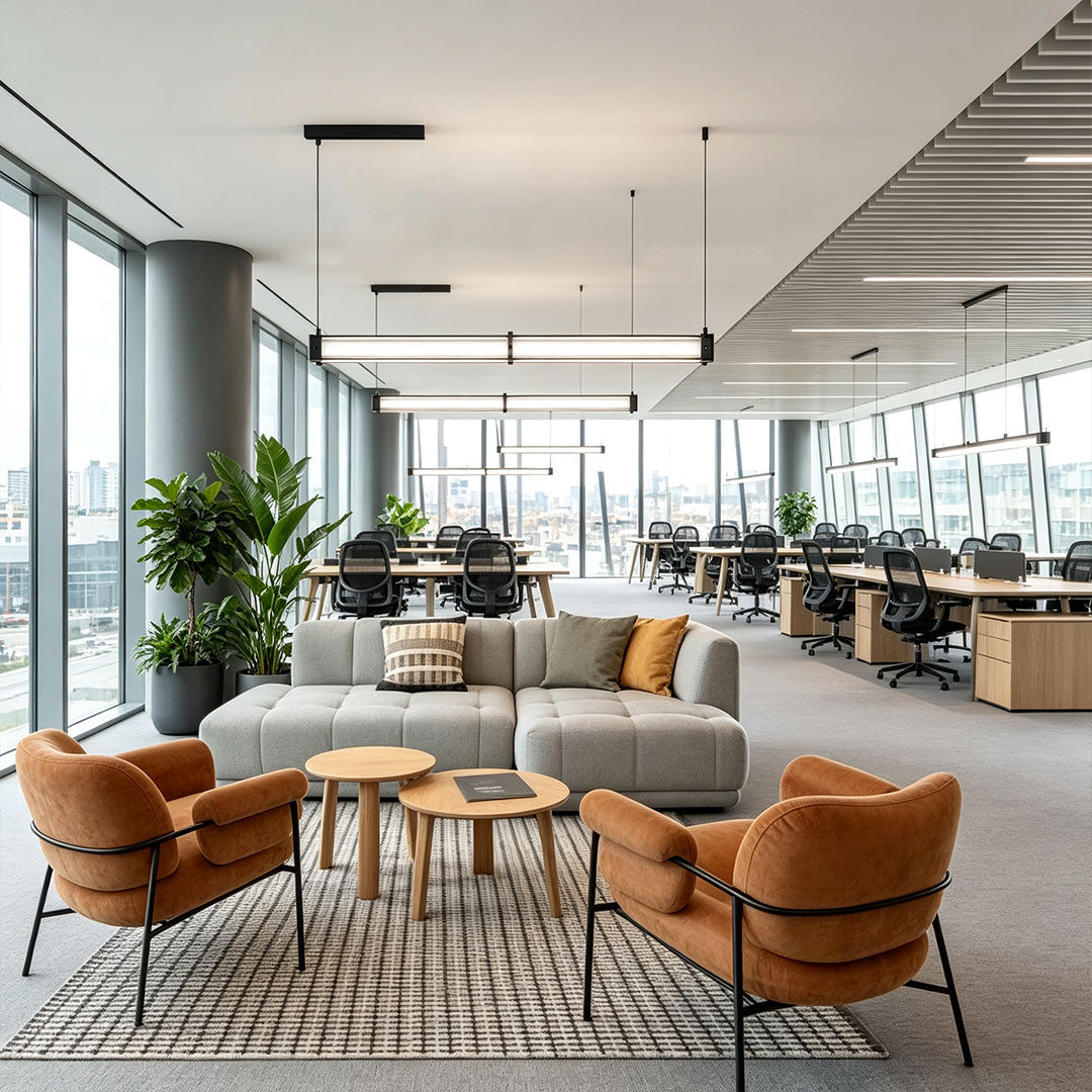 Sleek contemporary linear suspension lighting used in an open lounge office with modern furniture arrangement.