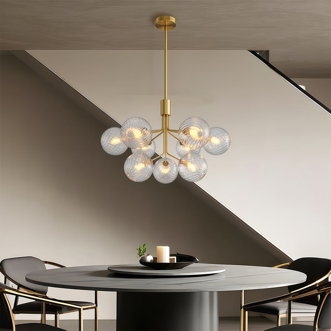 Contemporary luxury modern chandeliers with glass spheres, suspended above a minimalist dining table.