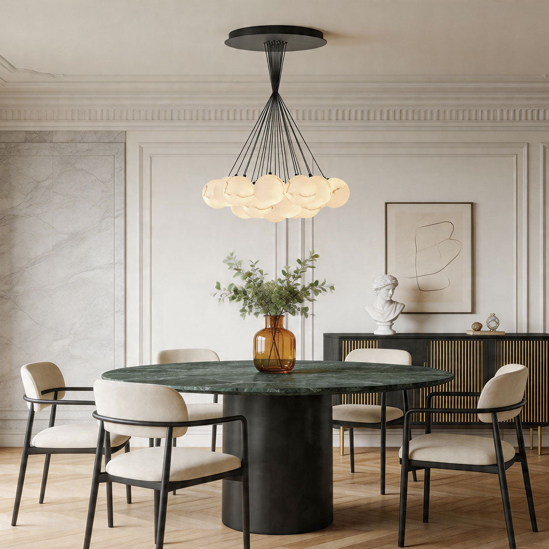 Contemporary matte black chandelier installed above a round dining table in a sophisticated interior.