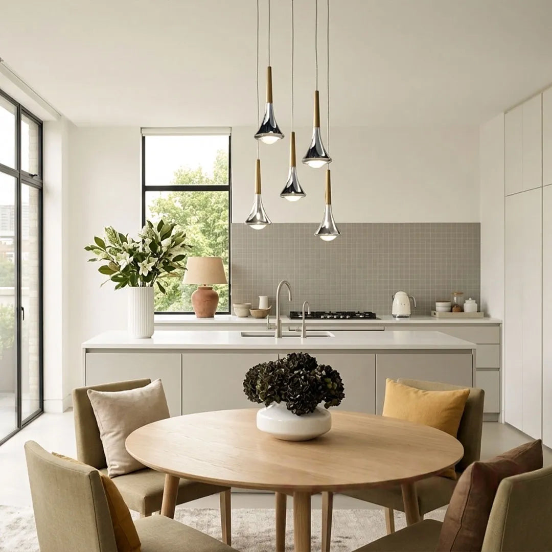 Contemporary mini pendant lights hanging above a dining table and kitchen island in a clean open-plan space.