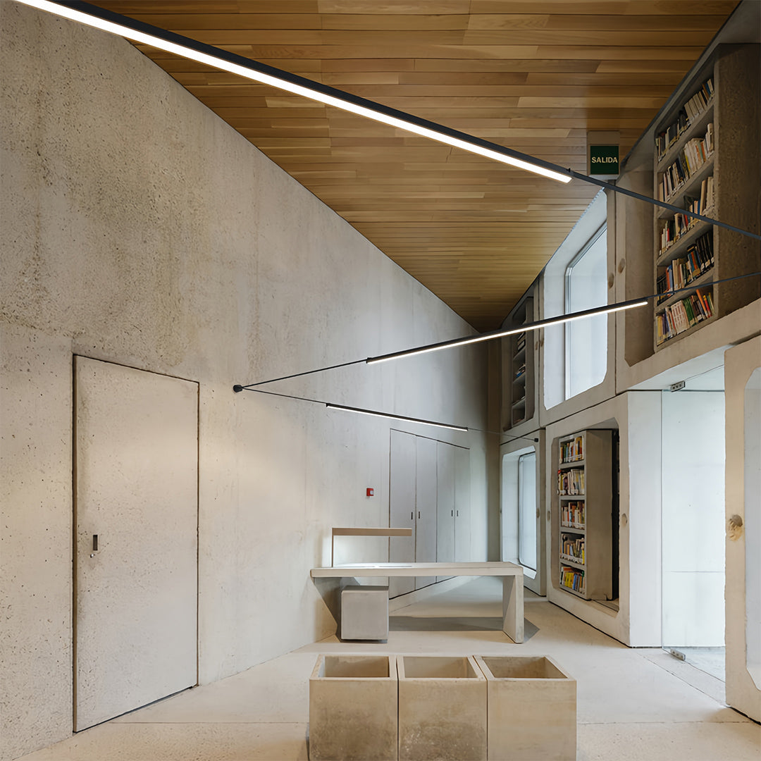 Contemporary office space with long pendant light fixtures, minimalist linear ceiling lighting