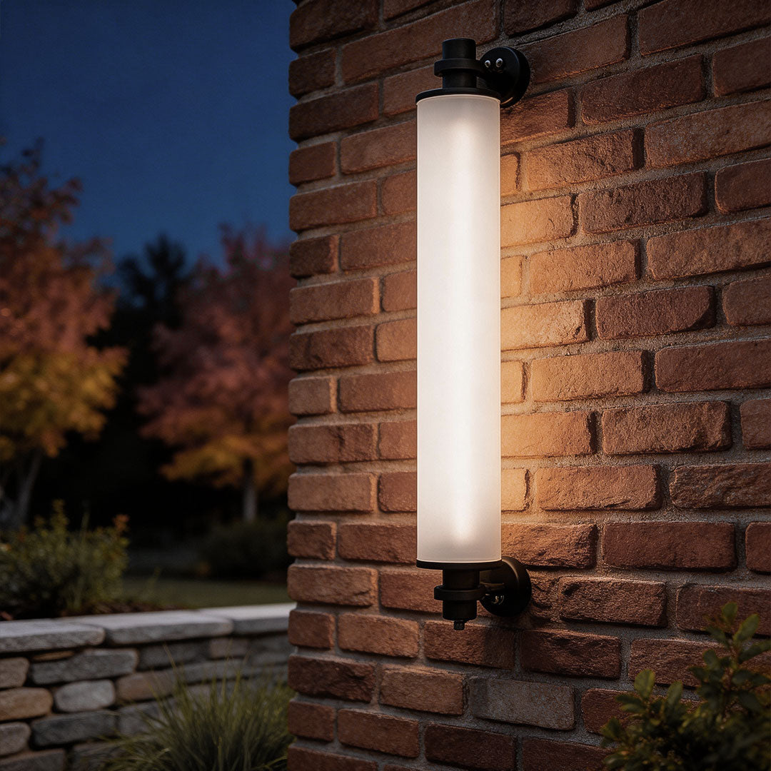 Contemporary outdoor LED wall lights with a sleek cylindrical design, mounted on a brick wall.