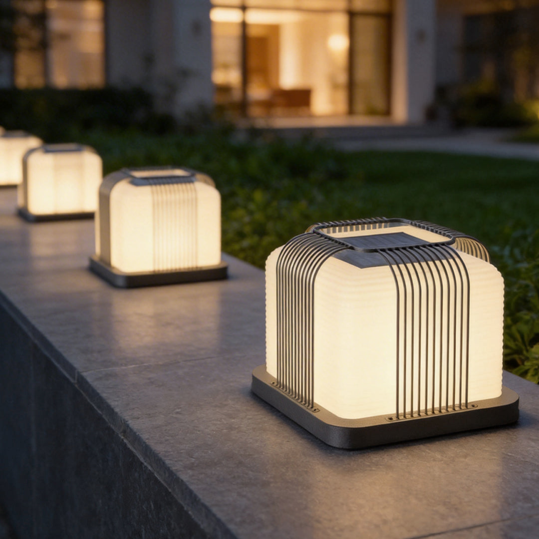 Contemporary outdoor pillar lights with a minimalist design, providing warm light near a pool.