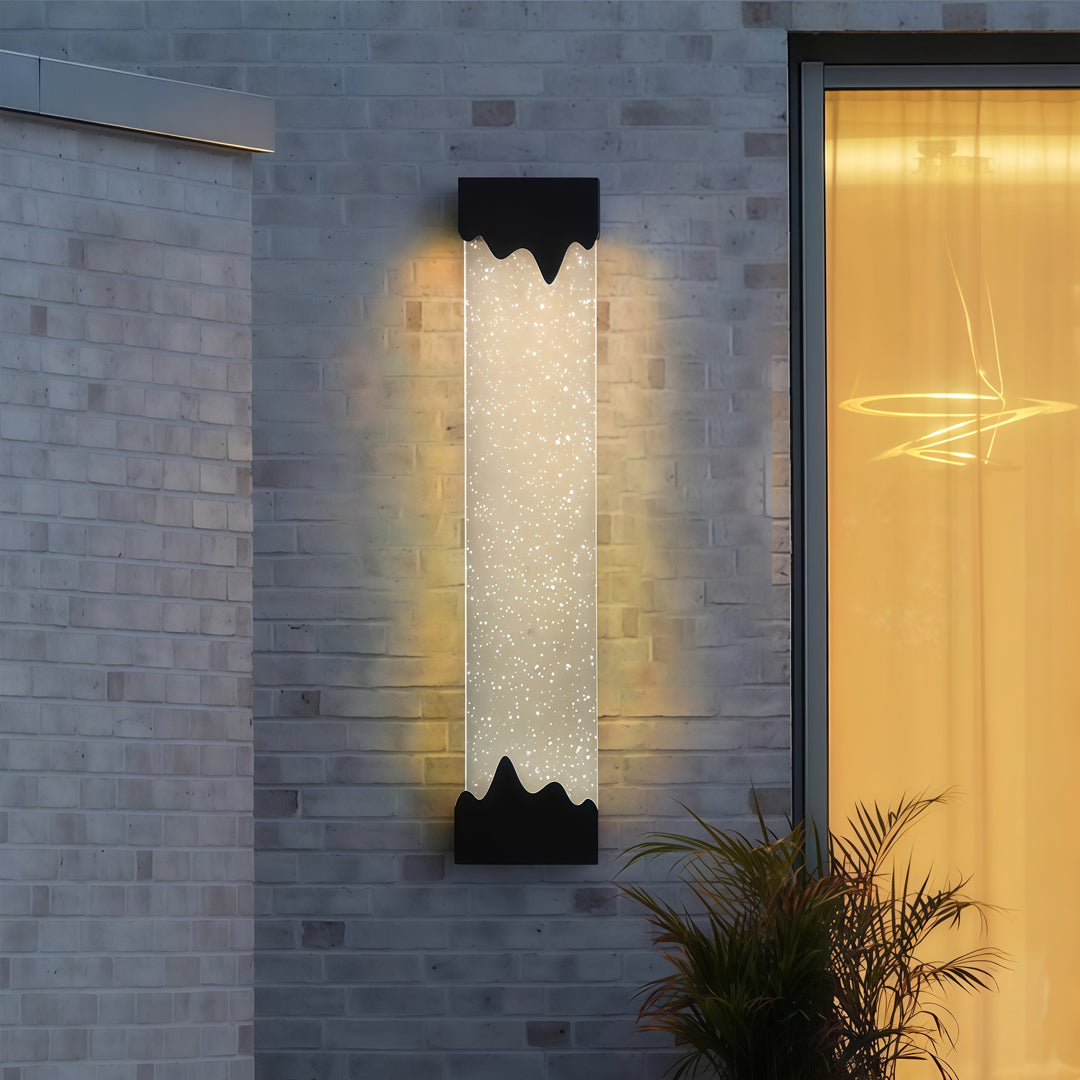 Contemporary outdoor wall lighting black linear sconce mounted on blue gray wall beside entrance and plant