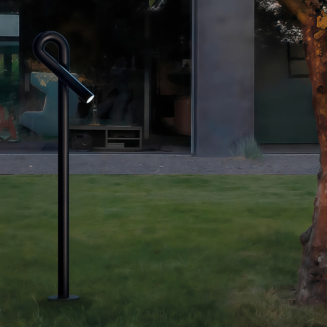 Contemporary outdoor wall lighting bollard light post creating ambient glow on grass near contemporary architecture