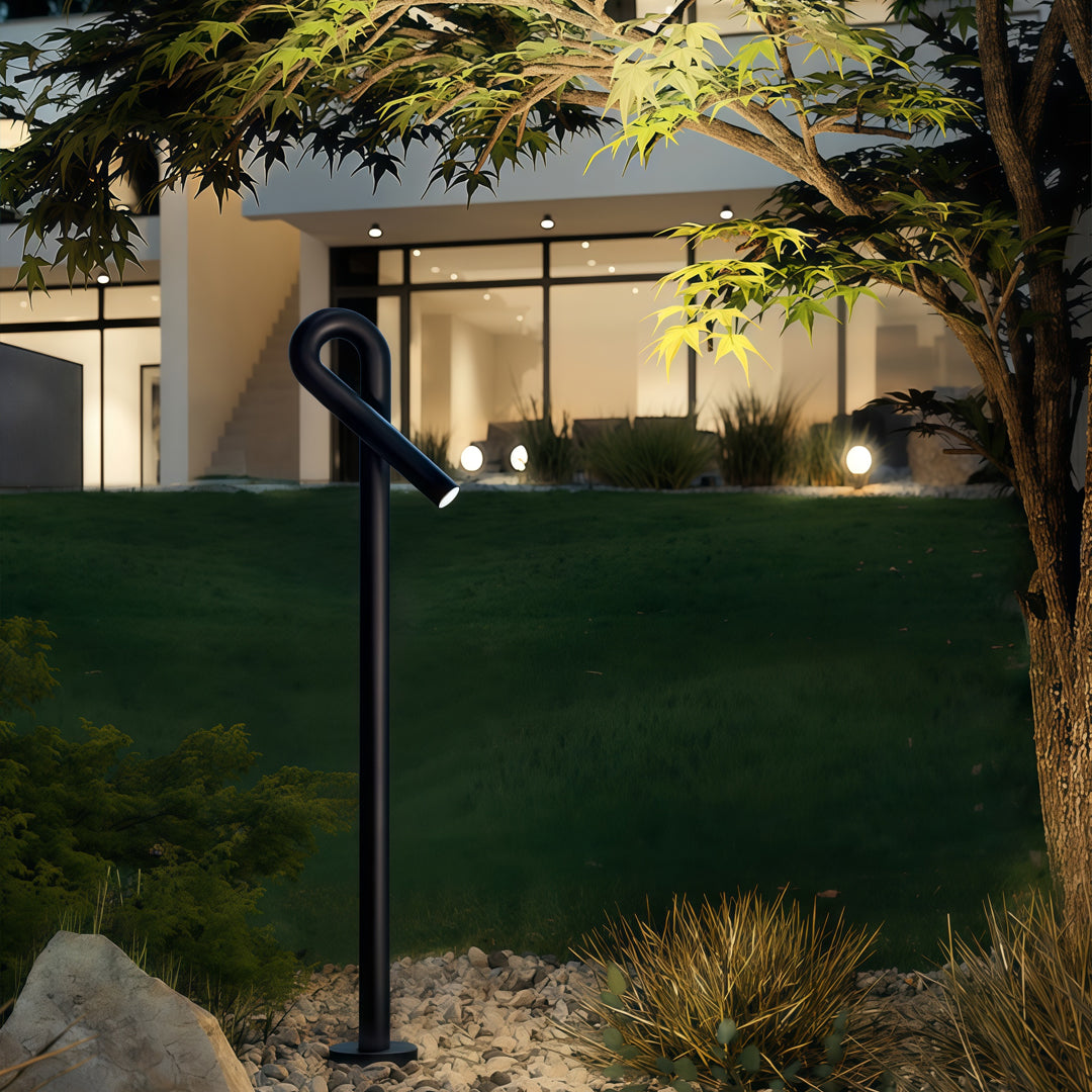 Contemporary outdoor wall lighting bollard light post on lawn beside modern home with warm evening illumination