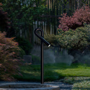 Contemporary outdoor wall lighting bollard light post in residential garden with autumn landscaping at twilight
