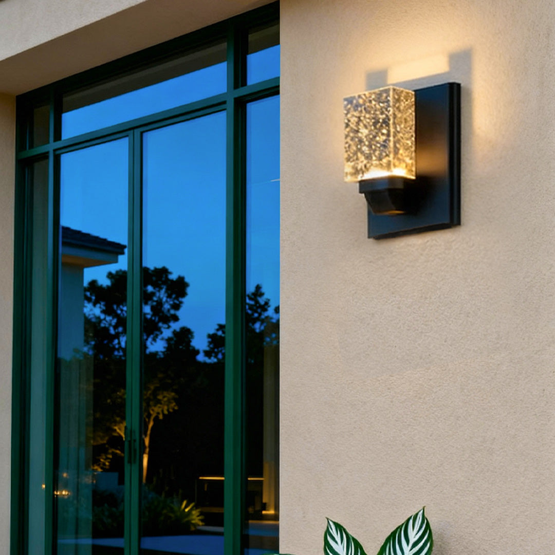 Contemporary outdoor wall lighting crystal sconce illuminating evening patio with blue hour ambiance