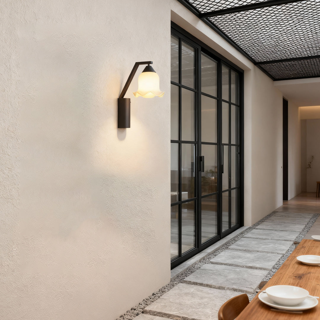 Contemporary outdoor wall lighting flower sconce creating welcoming ambiance on neutral exterior wall beside entryway
