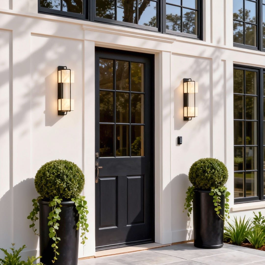 Contemporary outdoor wall lighting pair flanking black front door on white modern home entrance