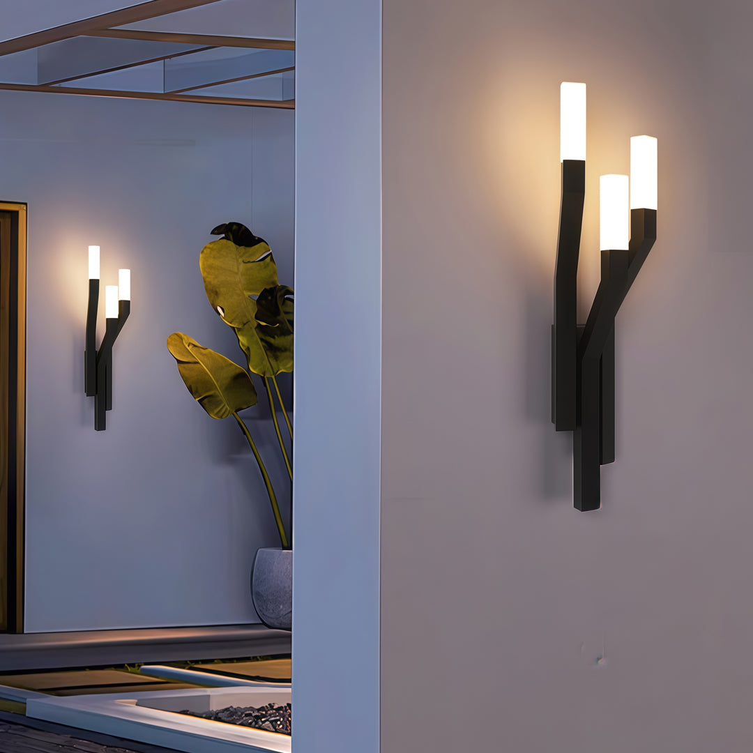 Contemporary outdoor wall lighting large sconces mounted on gray wall beside covered outdoor walkway at dusk