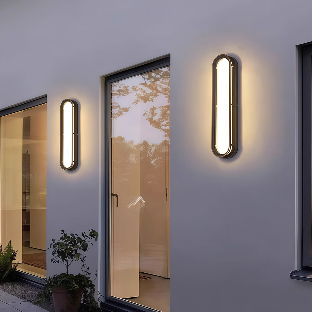 Contemporary outdoor wall lighting linear fixtures pair on gray walls beside artwork and modern home entrance
