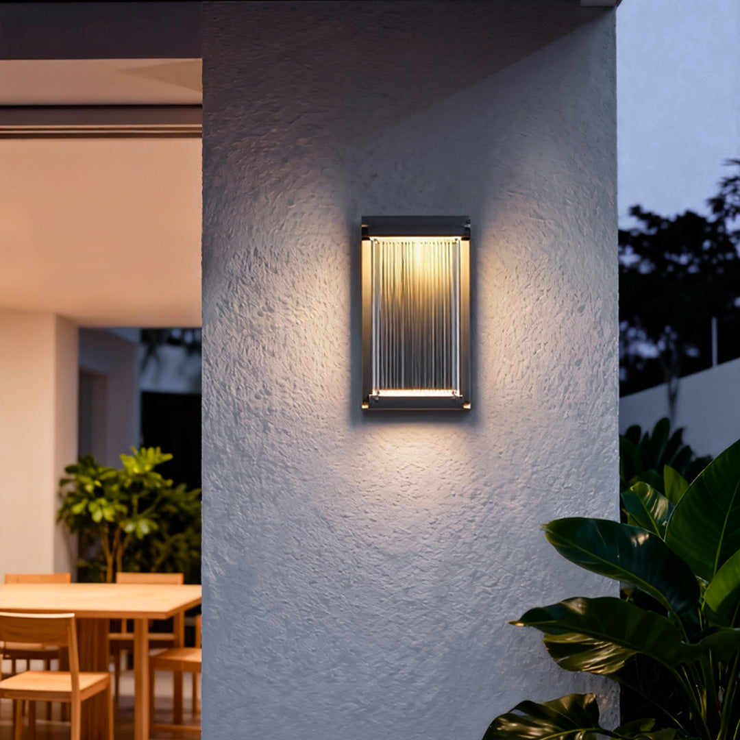 Contemporary outdoor wall lighting modern linear sconce illuminating textured purple exterior wall beside doorway