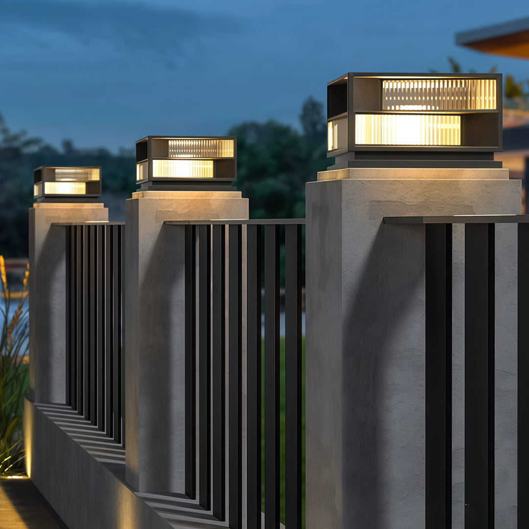 Contemporary outdoor wall lighting pillar LED fixtures on gray pillars creating dramatic evening architectural lighting