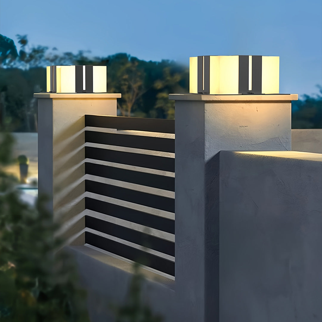 Contemporary outdoor wall lighting pillar LED fixtures illuminating modern gray architectural pillars at dusk