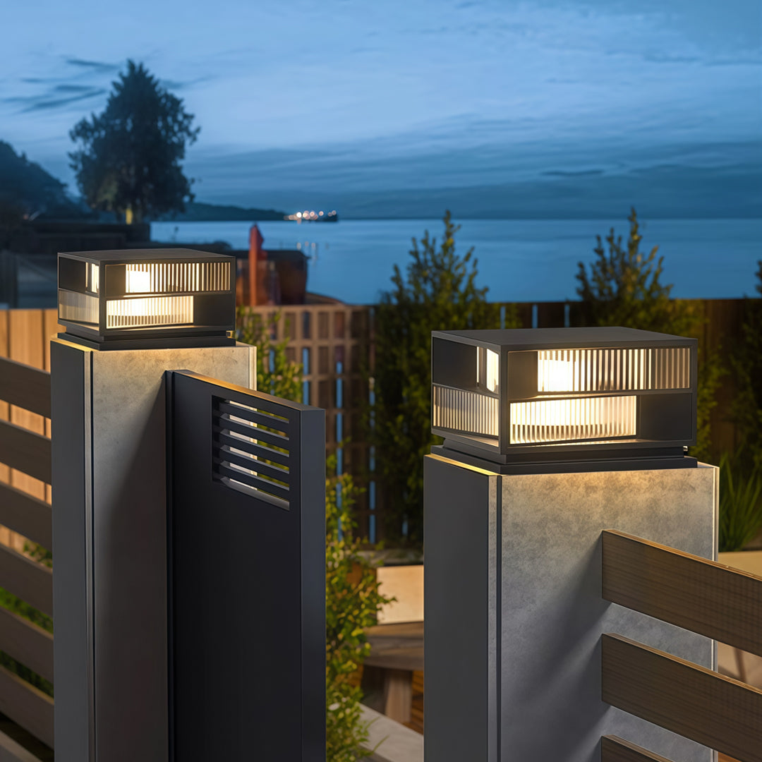Contemporary outdoor wall lighting pillar LED lights illuminating modern gray home exterior walls at blue hour
