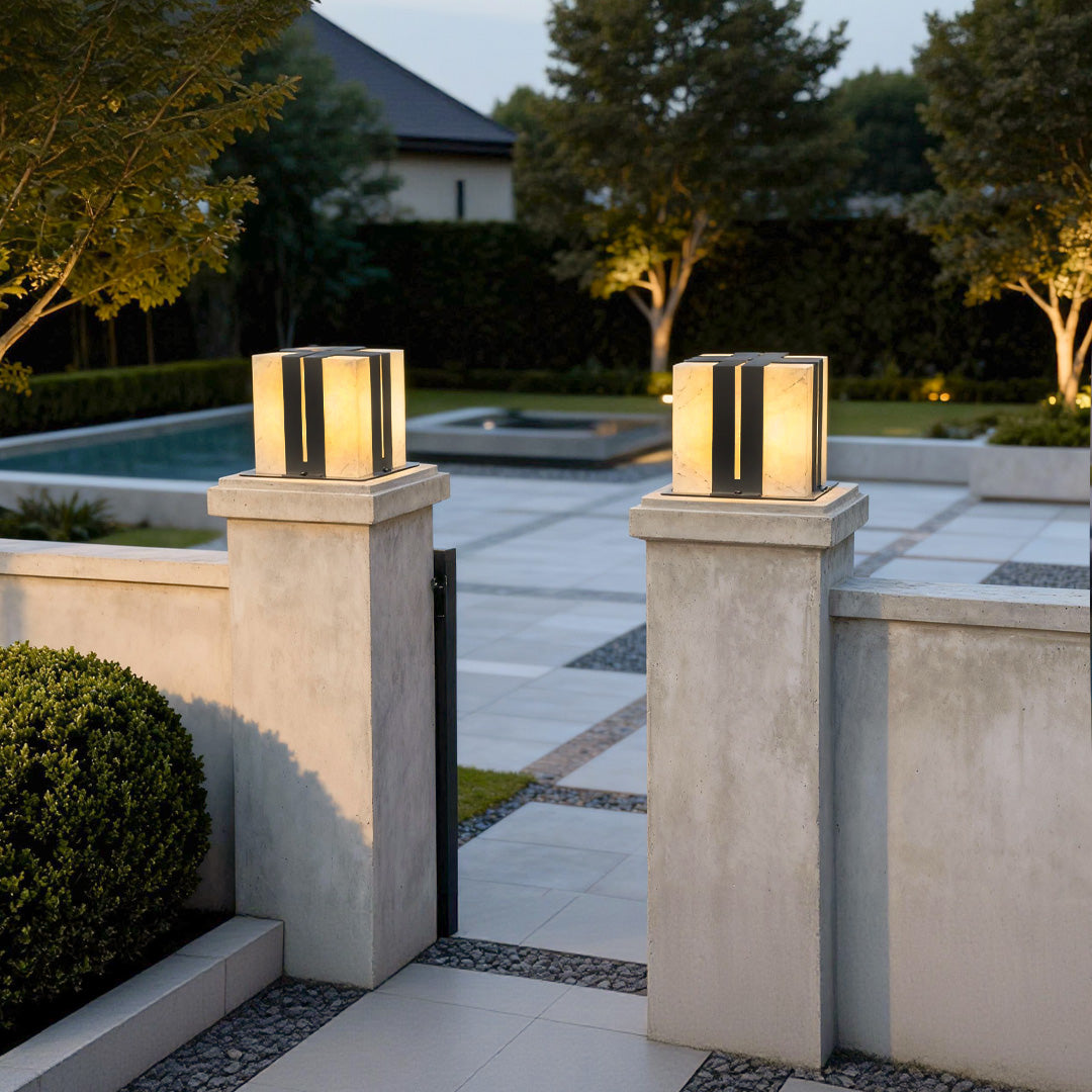Contemporary outdoor wall lighting pillar LED fixtures pair flanking modern poolside entrance at evening