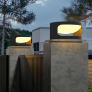 Contemporary outdoor wall lighting for pillar tops illuminating modern deck columns with tropical foliage at twilight
