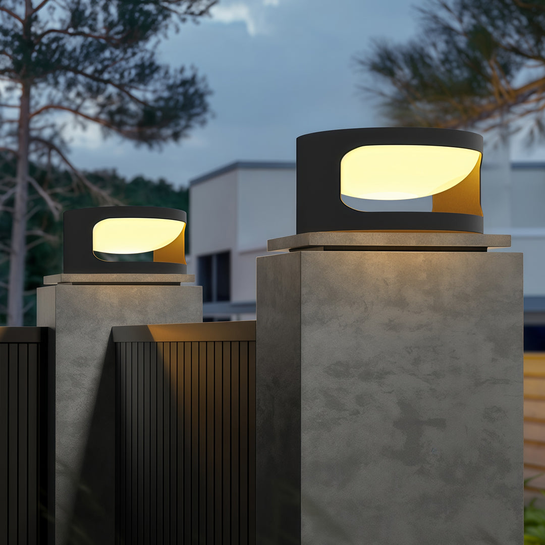 Contemporary outdoor wall lighting for pillar tops illuminating modern deck columns with tropical foliage at twilight
