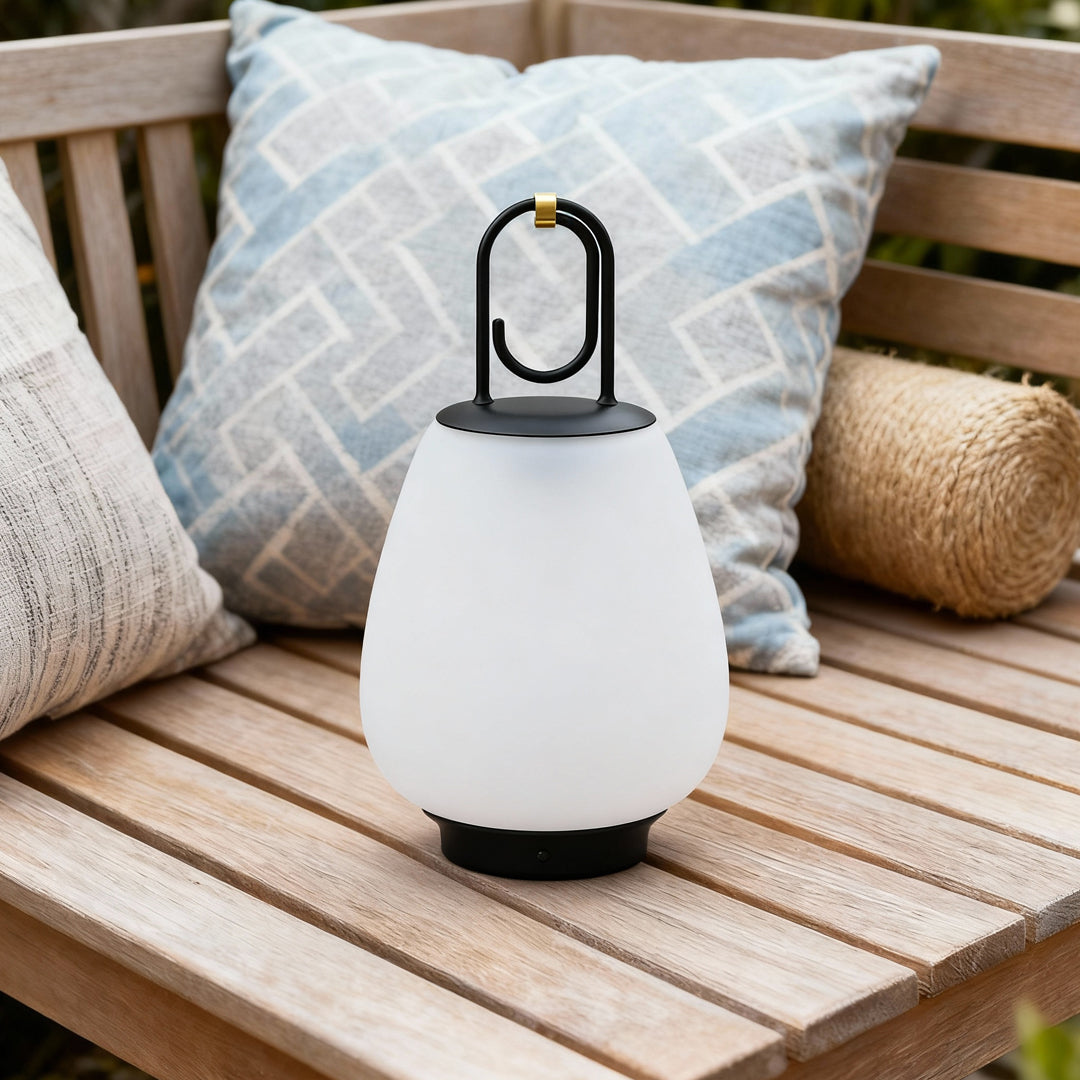 Contemporary outdoor wall lighting portable table lamp on wooden deck with striped pillow and woven outdoor furnishings