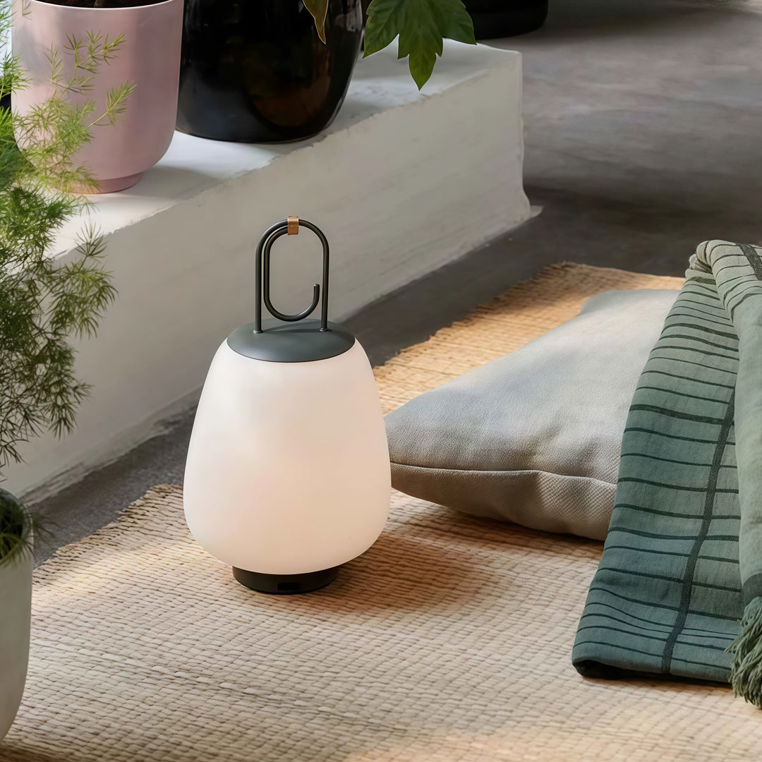 Contemporary outdoor wall lighting portable table lamp placed on textured rug with cozy home decor setting