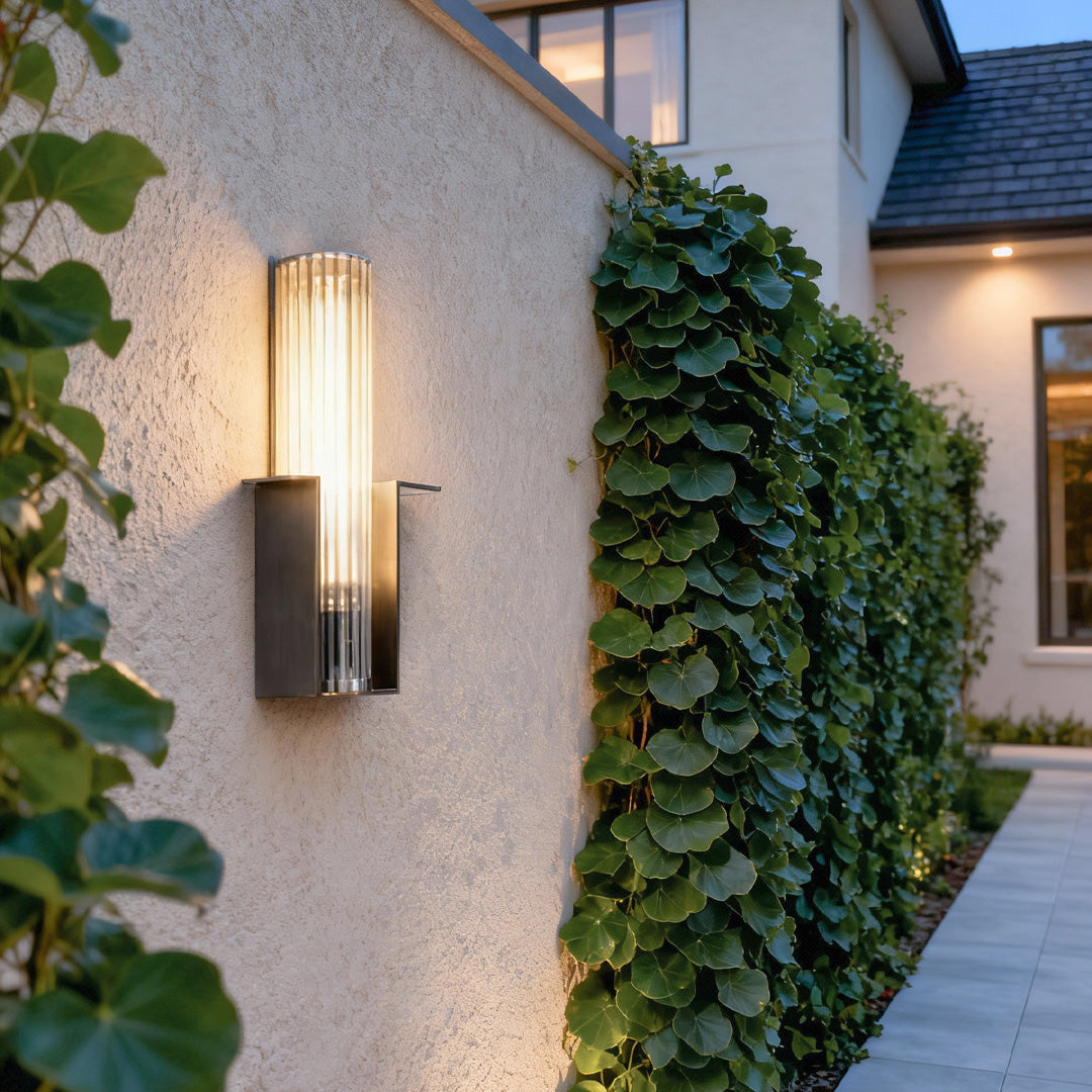 Contemporary outdoor wall lighting mounted on textured stone wall with evening ivy and greenery