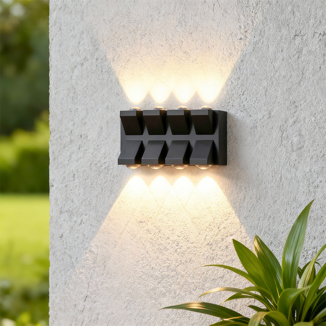 Contemporary outdoor wall lights black featuring glass shade chandelier styling creating striking up-down illumination on textured concrete.