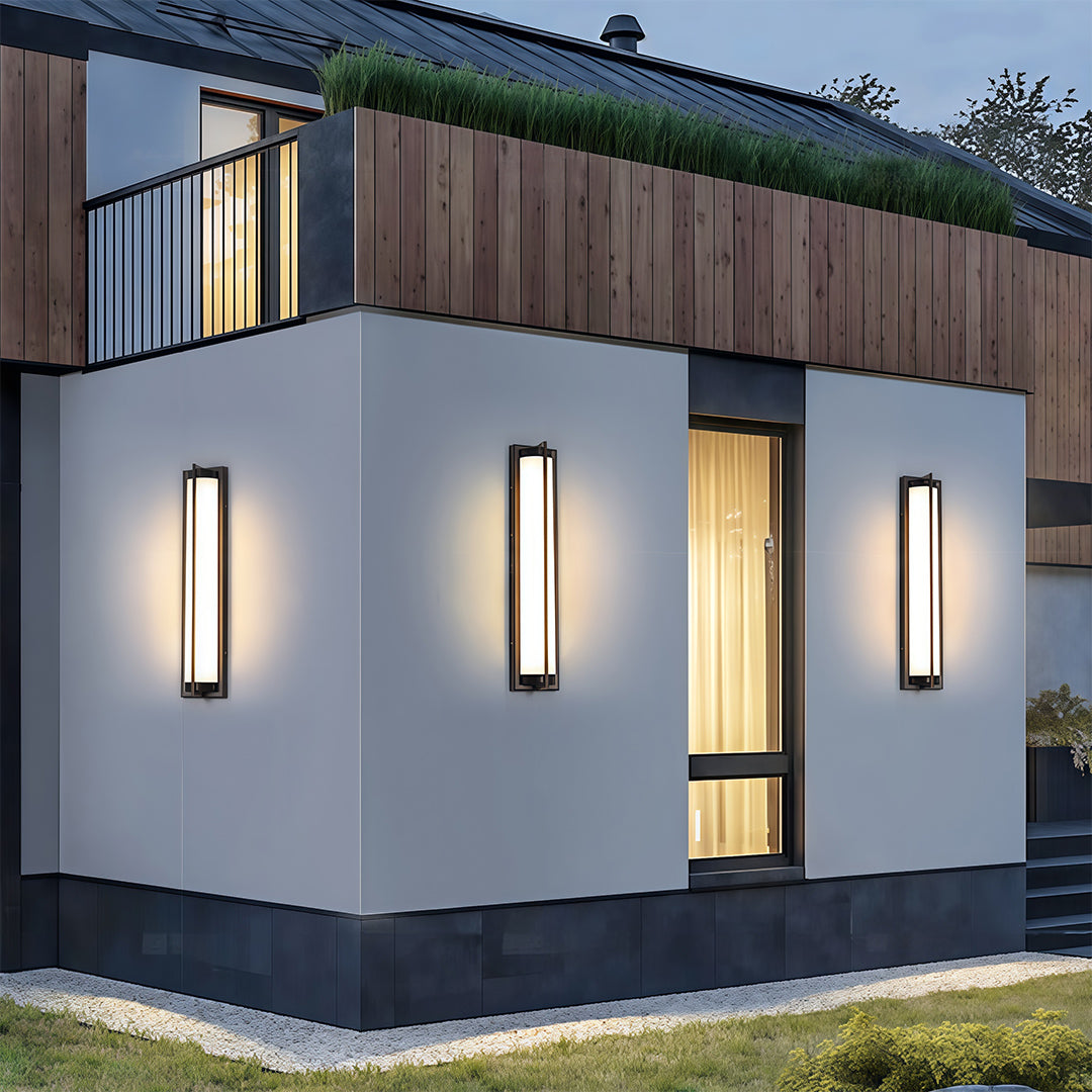 Contemporary outdoor wall sconces black with glass shade chandelier aesthetic creating dramatic accent lighting on modern blue and white exterior.