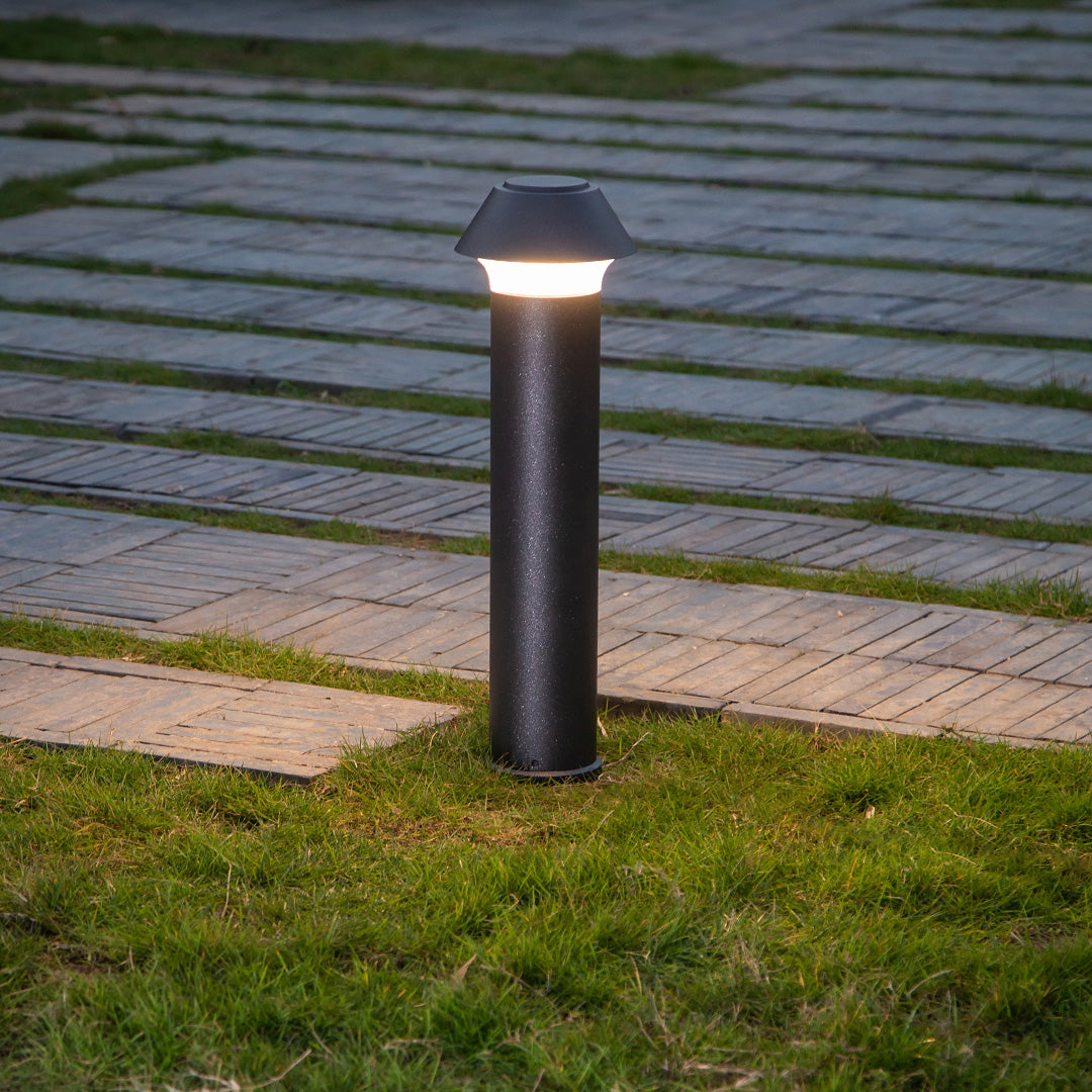 Contemporary pathway lighting installation showing pagoda bollards along paved walkway with landscaping