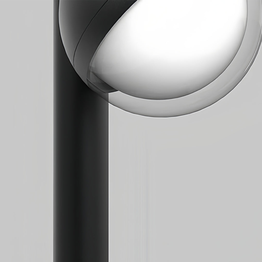 Contemporary pathway landscape lighting showcasing spherical fixture on vertical black pole with focused downlight