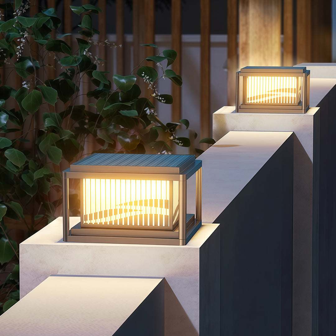Contemporary pillar lights arranged on white outdoor steps creating ambient entrance lighting at dusk.
